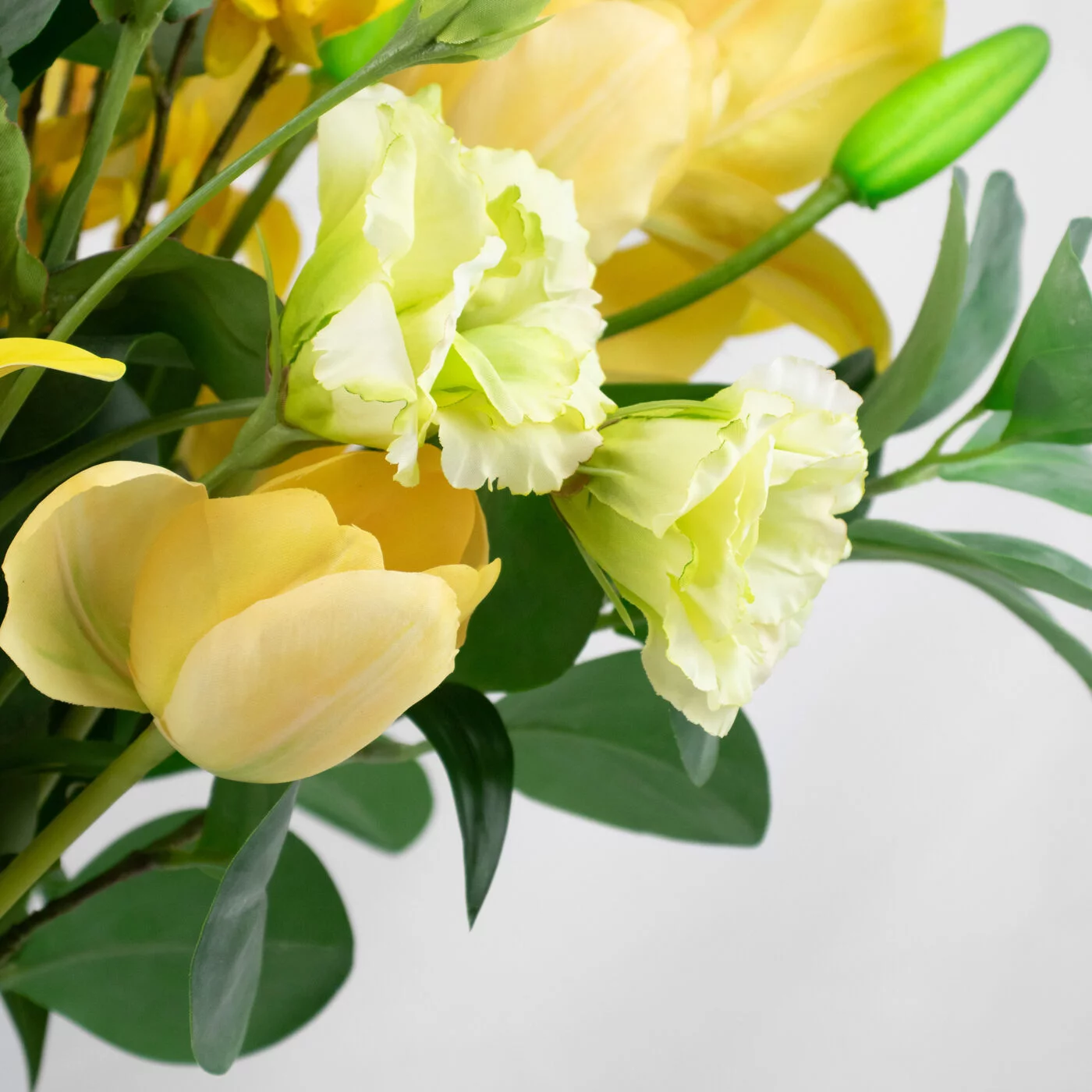 YELLOW LILY WITH FORSYTHIA IN SAGE GREEN GLASS VASE