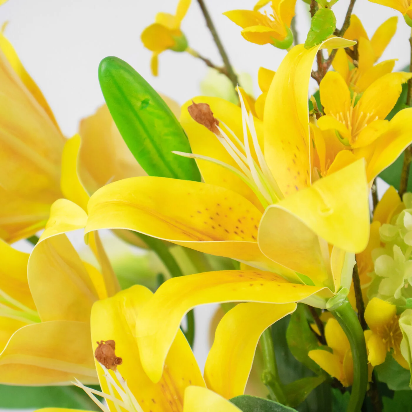 YELLOW LILY WITH FORSYTHIA IN SAGE GREEN GLASS VASE