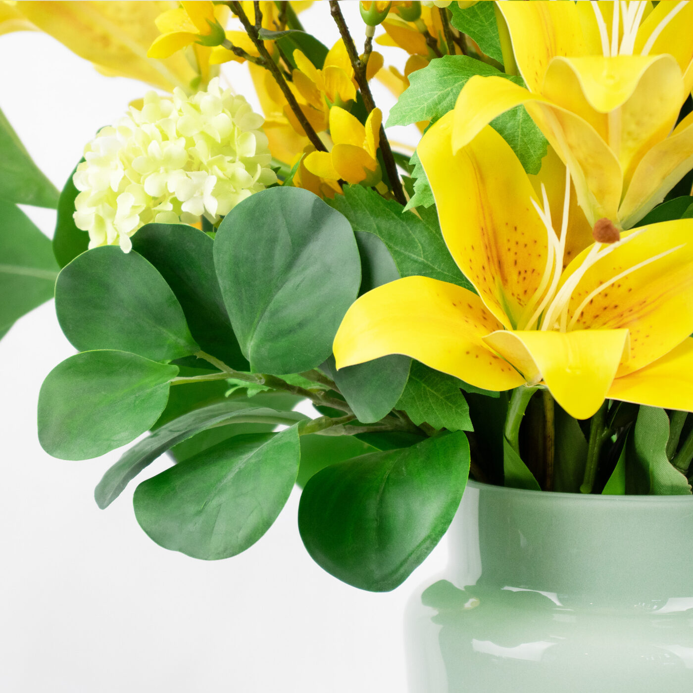 YELLOW LILY WITH FORSYTHIA IN SAGE GREEN GLASS VASE