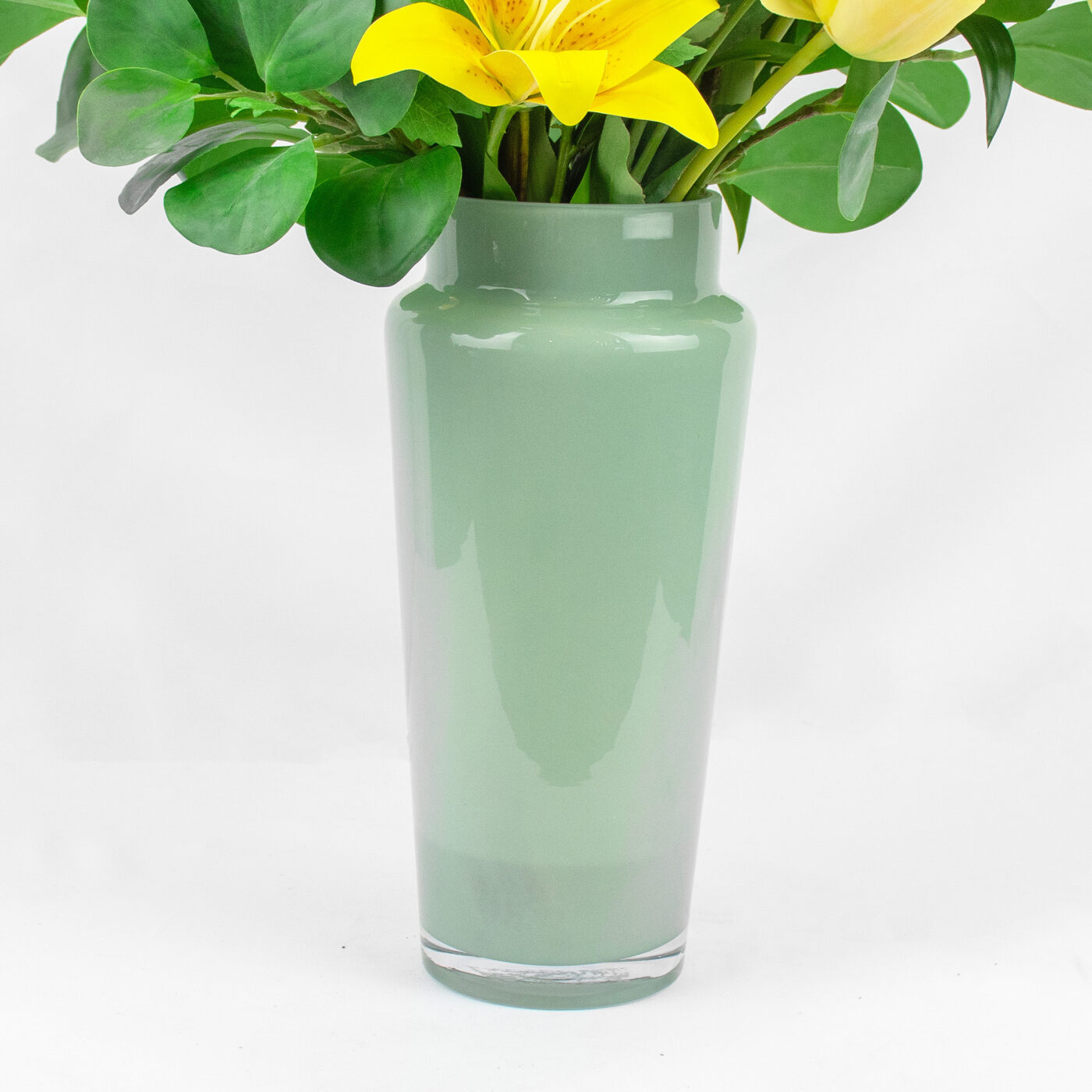 YELLOW LILY WITH FORSYTHIA IN SAGE GREEN GLASS VASE
